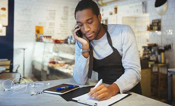 Man with apron talking on the phone