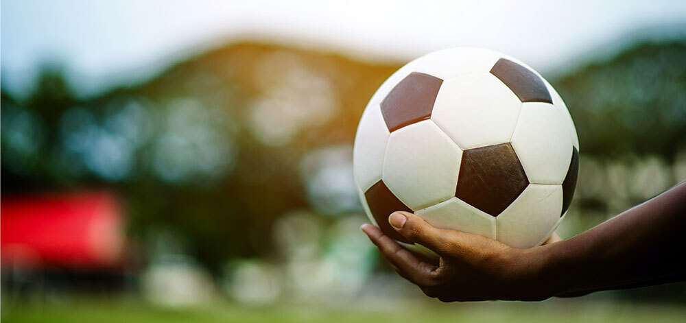 a hand holding a soccer ball