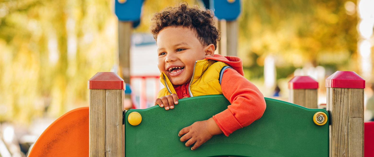 Child leaning over a playground