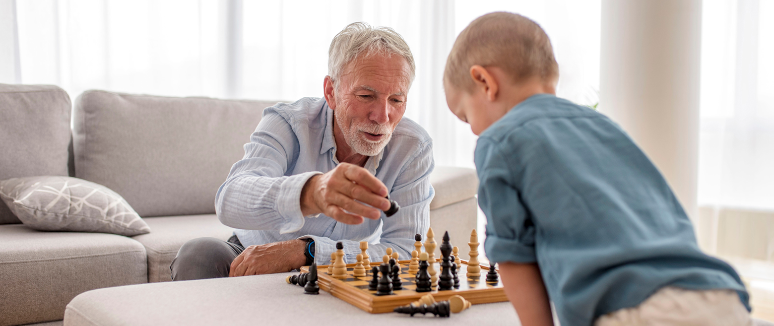Elder man and young child playing chess