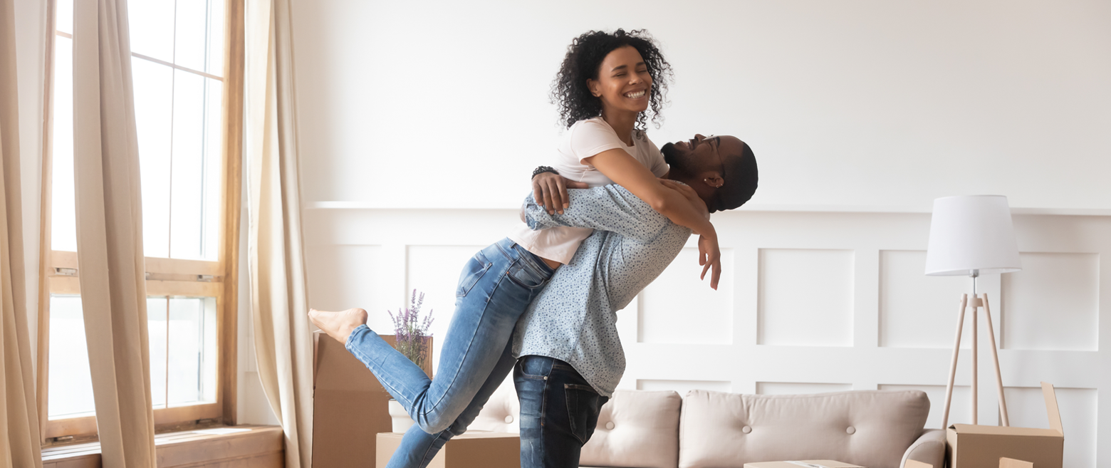 Couple hugging and celebrating in living room