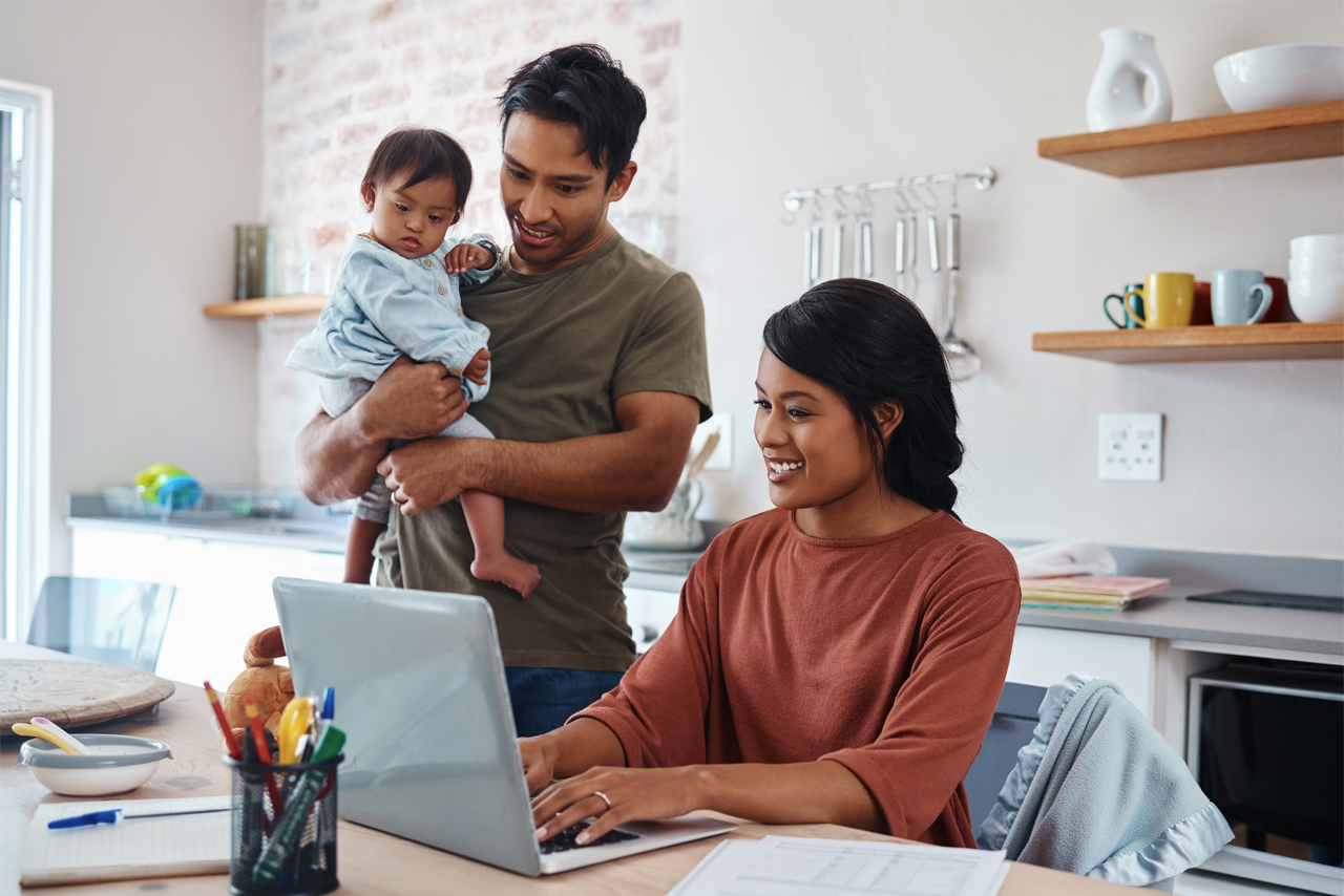Couple with a child looking at a laptop computer