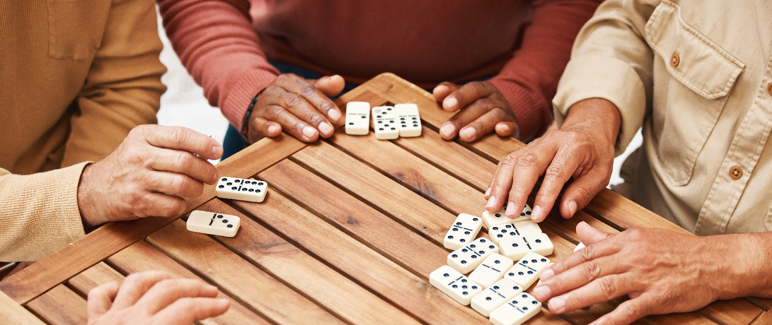 Men at a table playing dominos. 