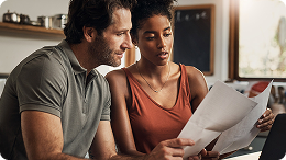 Woman and man looking at financial documents determining if ready to start investing